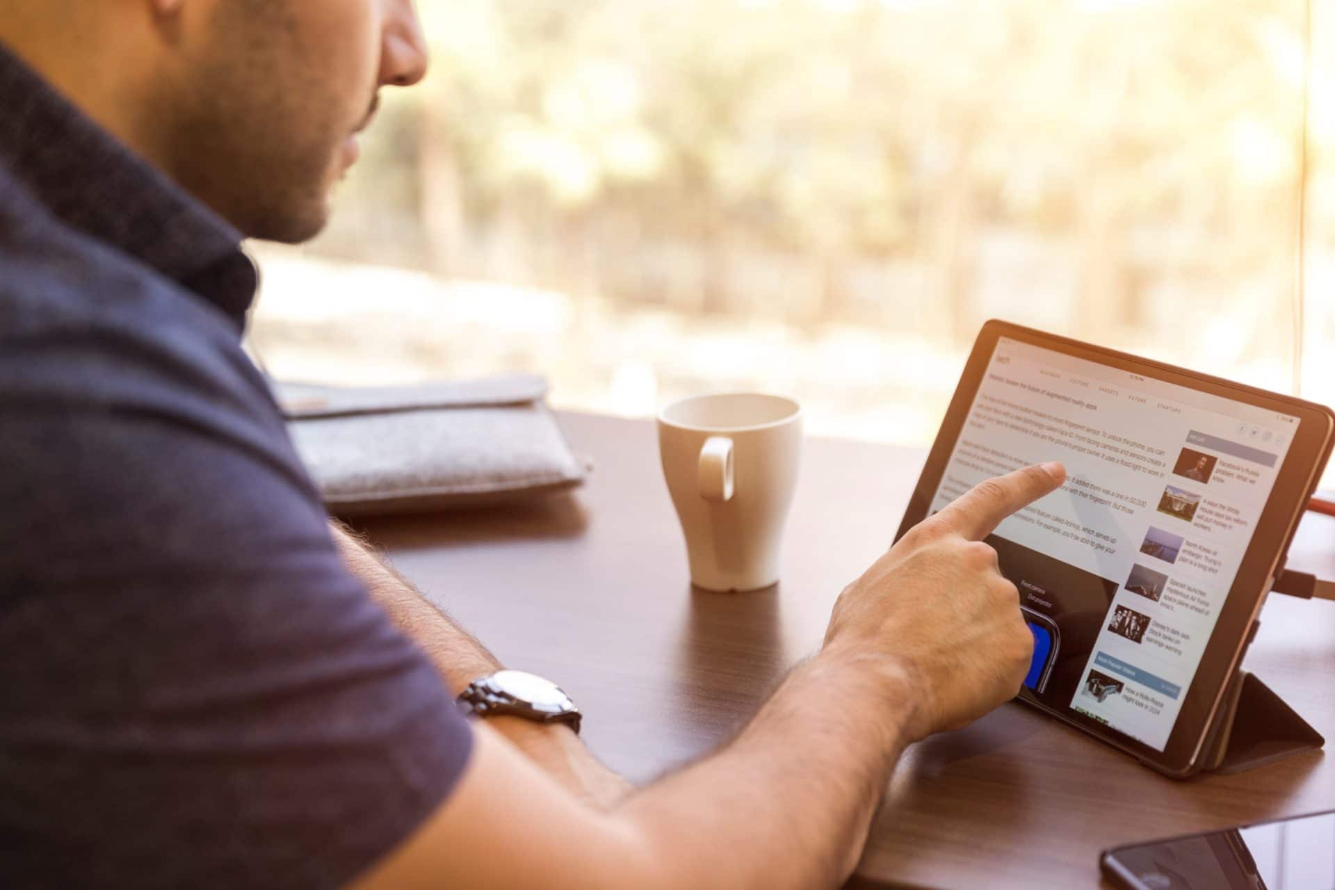 a man carefully reading on his tablet computer