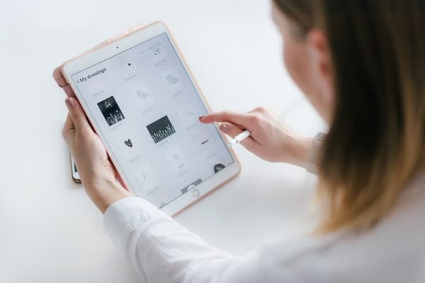 lady sitting beside table while using tablet
