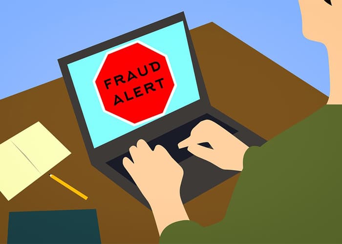 graphic illustration showing a man using a laptop with fraud notification appearing on screen